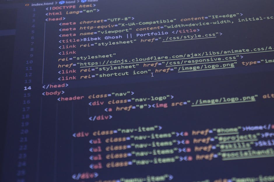 A close-up image of a laptop placed on a wooden desk shows a dark-themed coding interface with lines of colorful code text displayed on the screen. Next to the laptop, there is a ceramic coffee mug wi